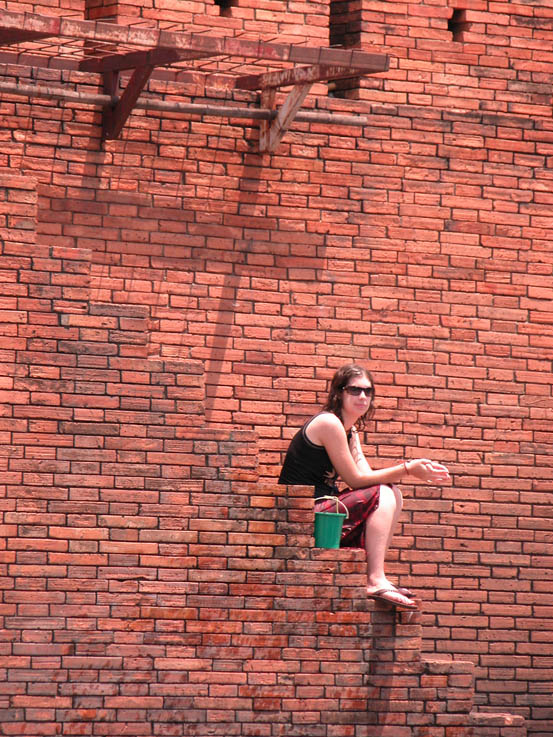 A woman finds a safe place (maybe) on the Old Chiang Mai wall.
