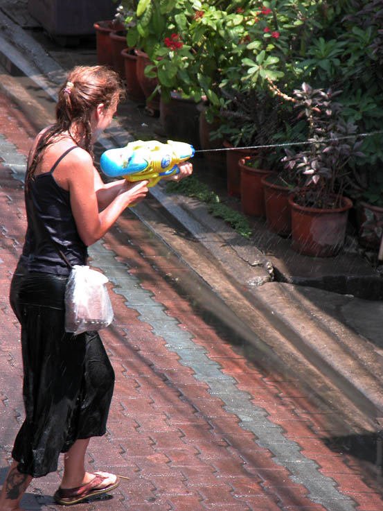 A mum shows her son how it's done at Songkran.